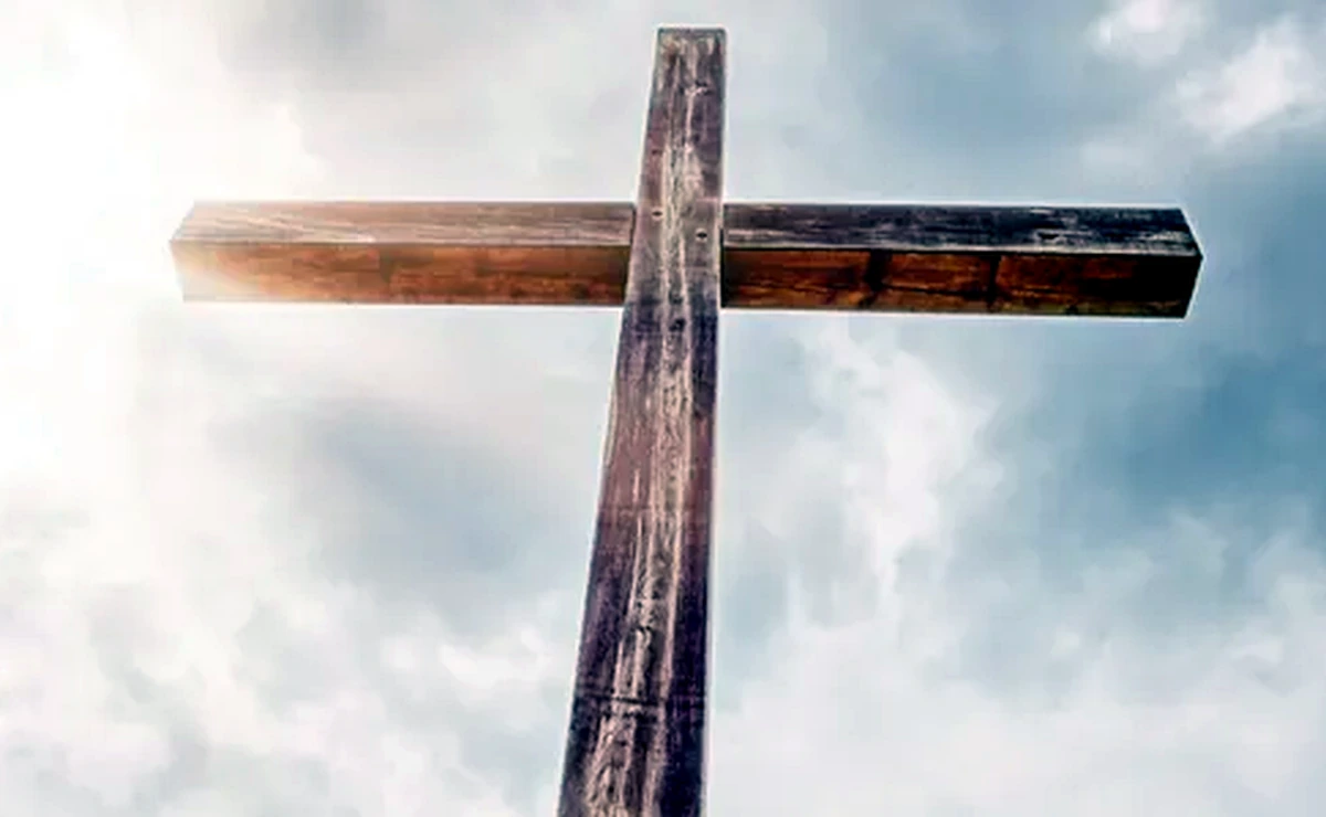 Wooden cross against a bright sky